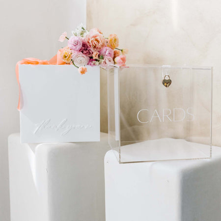 Elegant clear and white acrylic card holder with a heart-shaped lock, perfect for wedding